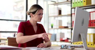 Odaklanmış kadın yönetici bilgisayar monitörünü işaret ediyor. Raporda iş hatası