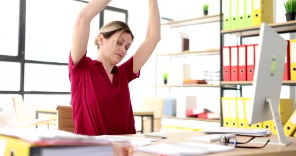 在办公室的工作场所 女人伸出手来 经理休息时坐在工作场所做一些简单的练习 — 图库视频影像