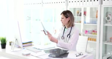 Doktor terapist travmatolog klinikteki röntgenlere bakıyor. İç organların ve iskelet kemiklerin ultrasonu.