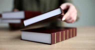 Kadın eli, hukuki faaliyetlerle ilgili kitap ve kitapları masaya koyar. Adalet ve yasalar hakkında adli uygulama ve edebiyat