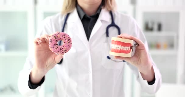 Tandarts Houdt Plastic Kaken Zoete Roze Donut Vast Begrip Tandheelkundige — Stockvideo