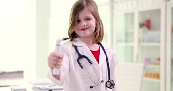 一个带着耳镜的美丽微笑的医生女孩的画像 孩子想成为医生和儿时的梦想 — 图库视频影像