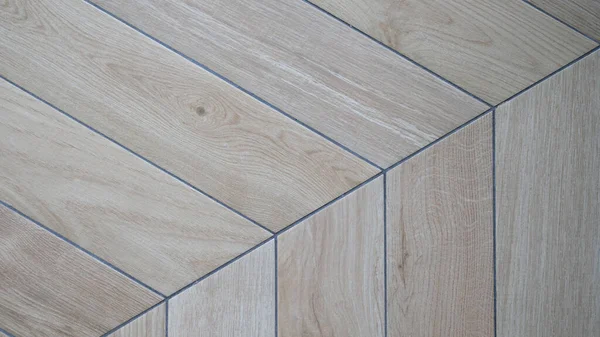 Wooden laminate on floor in shape of tree closeup. Laying laminate flooring finishing concept
