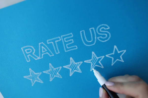 stock image Person paints star next to message rate us. Rating and evaluation of customers concept