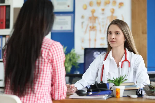 Woman is listening to general practitioner or gynecologist in clinic office. Professional surgeon cardiologist therapist giving patient medical advice and health insurance