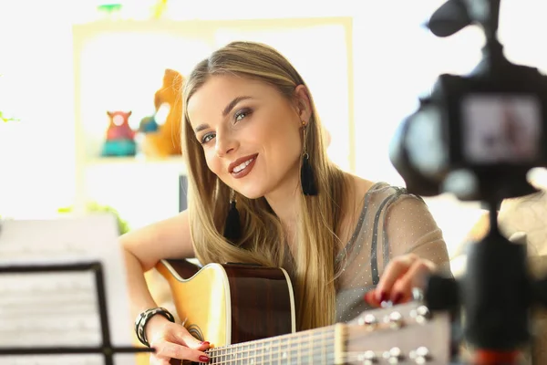 金发女子在镜头前弹奏吉他 女孩领导的音乐视频博客概念 — 图库照片