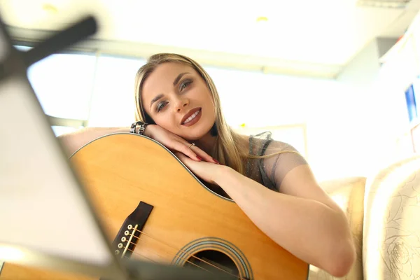 年轻漂亮的女人在家里弹吉他 学习弹吉他和音乐的概念 — 图库照片