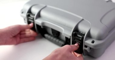 Genç eller gri bir valizin kilitlerini açıyor, yakın plan. Kavram yolculuğu, yolcu bagajı, ulaşım