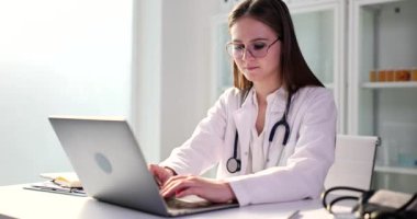 Genç bir kadın dizüstü bilgisayarında doktorunu daktilo ediyor. Yakın plan. Tıbbi belgeler, teşhis