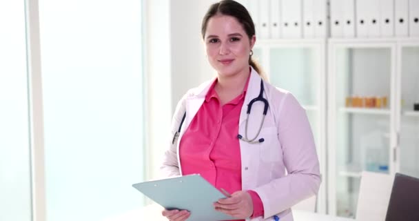 医者が握手のために手を差し出している笑顔の女性 クローズアップ 診療所での挨拶 — ストック動画