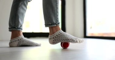 Çorapların bacakları yerdeki masaj topuna kadar uzanıyor, yakın plan. Ayak masajı, rahatlama.