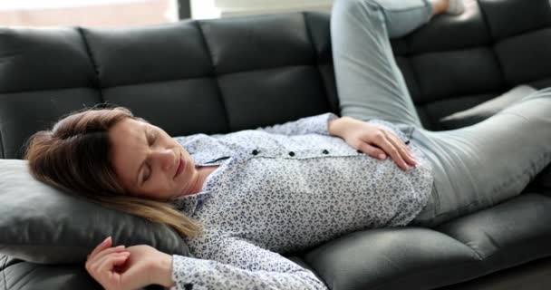 一个疲惫的年轻女人睡在一个黑色的沙发上 一个特写 笨重的睡眠概念 舒适的沙发 慢动作 — 图库视频影像