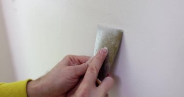 Eldeki duvarları yıkmak için, yakın plan bir spatula. Messual araç, ev onarımı, yavaş çekim