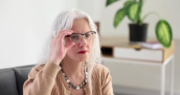 Mulher Idosa Com Cabelos Grisalhos Ajustando Óculos Casa Filme Câmera — Vídeo de Stock