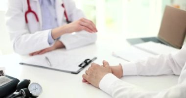 Doktor hastaya elini uzatıyor ve yakın çekim 4K filmi ağır çekimde sempati duyuyor. Tedavisi olmayan hastalara psikolojik yardım