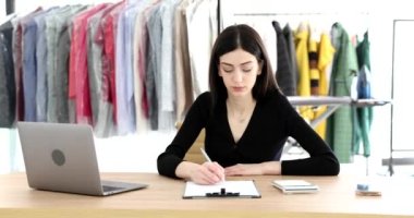 Kuru temizlemeci kadın ve çamaşırcı kadın masada oturuyor ve hesap makinesinin 4K filmindeki gelirleri sayıyor. Küçük işletme konseptinde kar ve vergi ödemek