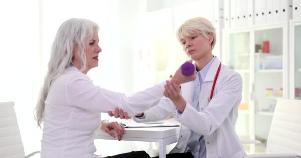 Arzt Rehabilitologe Zeigt Übungen Für Die Handmuskulatur Mit Hanteln Älteren — Stockvideo