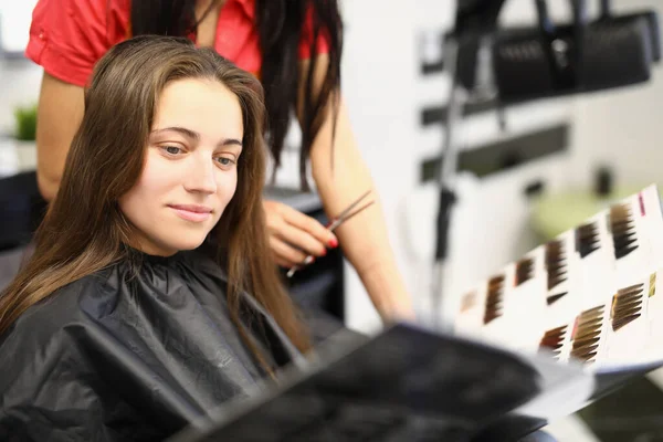女性客户在产品目录中选择染发和染色 从美容院的概念出发准备染发 — 图库照片