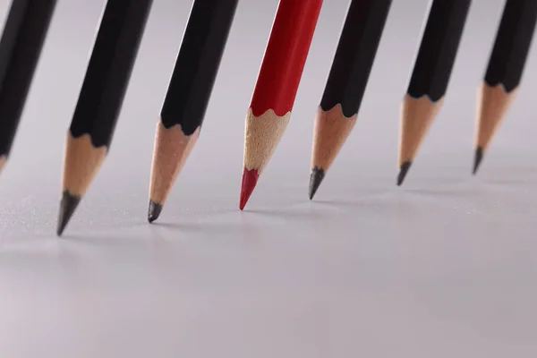 Jasnoczerwony Ołówek Wyróżnia Się Identycznymi Czarnymi Ołówkami Inna Koncepcja Pracy — Zdjęcie stockowe