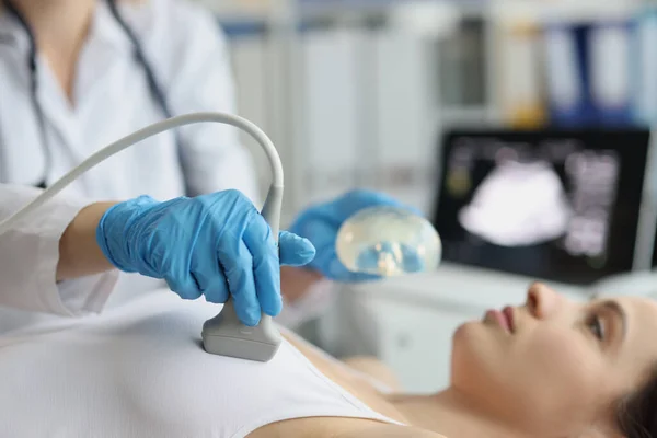 女性医師は超音波装置を用いて女性の乳房を調べる 乳腺の超音波と乳房シリコンインプラントに関する乳腺科医の相談 — ストック写真