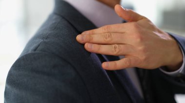 Takım elbiseli bir iş adamı omzundan toz veya kepek temizliyor. Bırak ve sorunlardan kurtul.