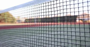 Tenis topu uçar ve spor sahasında ağır çekimde sallanır. Atletizm yarışması ve eğitim ekipmanları. Açık hava çocuk parkında etkinlik