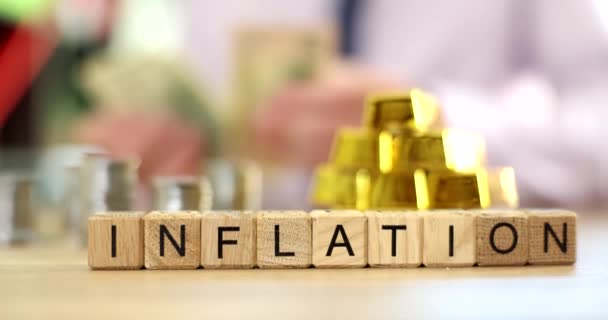 Word Inflation Wooden Blocks Blurry Person Counting Money Gold Bars — Stock Video