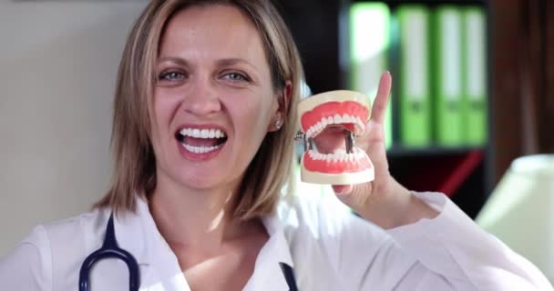Emotional Female Dentist Stethoscope Shows Model Dental Jaws Imitating Biting — Stock Video