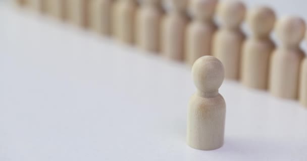 木制的人物形象站在白色的桌子上 与一排小的人物形象相对立 领导和下属概念 有效的人群影响能力 — 图库视频影像