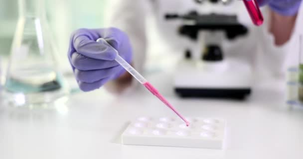 검사를 피펫이 흐르는 분홍색 액체를 고무장갑을 과학자의 대실험실의 장비를 — 비디오