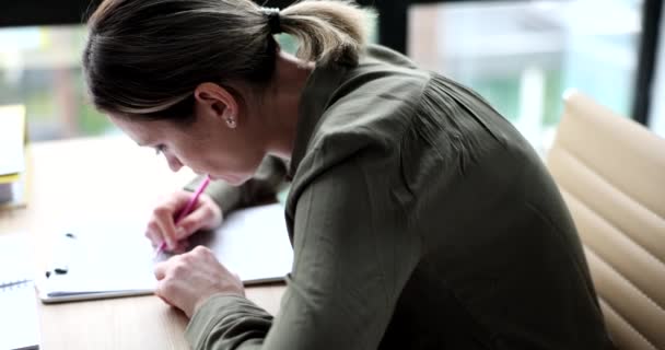 Εστιασμένη Γυναίκα Γράφει Σημειώσεις Χαρτί Σημειωματάριο Στυλό Κάθεται Στο Τραπέζι — Αρχείο Βίντεο