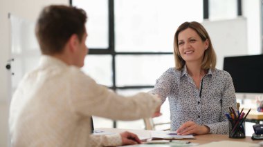 İş ortakları toplantıda masada el sıkışıyor. Takım çalışması konsepti