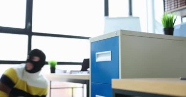 Kar maskeli bir hırsız, ofis filminde metal dolaptan dokümanlarla birlikte sarı zarf çalıyor. Kişisel veri konsepti sızıntısı