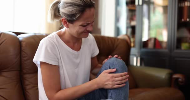 여성은 소파에 통증을 손으로 통증을 완화하는 마사지를 입술의 움직임을 제거하느라 — 비디오