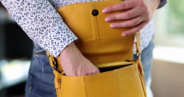 Kadın mesajları kontrol etmek için sarı el çantasından akıllı telefonu alıyor. Bluzlu kadın çalışan, ağır çekimde çalıştıktan sonra telefona cevap vermek için aygıt kullanır.