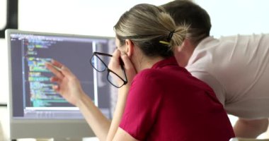 Programcılar ofisteki monitöre bakan kod yapısını tartışıyor. Proje yöneticisi ve mühendis dijital verileri kontrol ediyor. Yazılım geliştirme teknolojisi