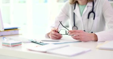 Gözlüklü kadın terapist klinik dolabında tıbbi kayıtlarla masada oturuyor. Aile doktoru randevudaki hastayı dinler. Hastanede profesyonel danışmanlık