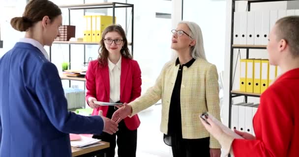 戴眼镜的快乐成熟女性与年轻男性握手 表达对同事们的感激之情 商业伙伴成功交易慢动作 — 图库视频影像