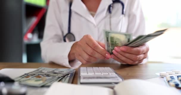 Kobieta Mundurze Medycznym Liczy Dolary Używając Kalkulatora Lekarz Stetoskopem Trzyma — Wideo stockowe