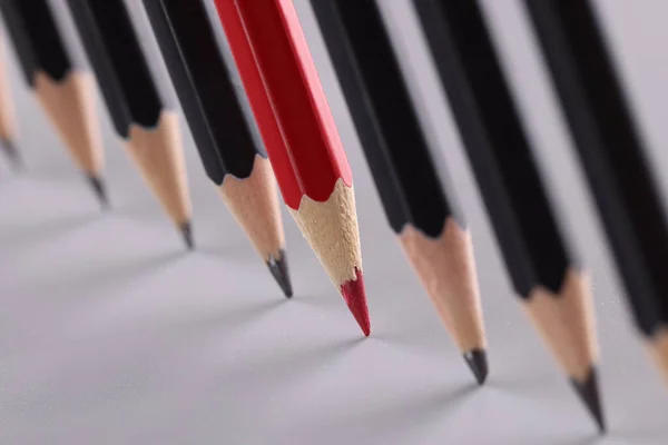 Ostry Czerwony Ołówek Wyróżnia Się Identycznymi Czarnymi Ołówkami Szarym Tle — Zdjęcie stockowe
