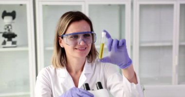 Bilim adamı test tüpünde saydam sarı sıvıyı test ediyor. Petrol ürünlerinin kimyasal verilerinin toplanması kavramı