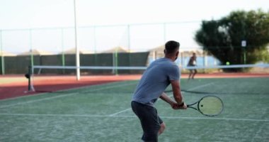 Tenis kortunda tenis oynayan kadın ve erkek. Spor eğitimi ve sağlık.