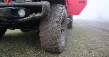 Off-road 'a çıktıktan sonra kirli SUV' nin tekerine yaklaşıyoruz. Kırsal yolda çamurla kaplı bir SUV.
