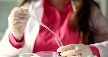 Laboratuvar asistanı test tüpüne sarı sıvı atıyor. Petrol kalite kontrolü ve laboratuvar deneyi