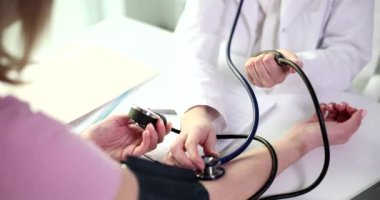 Doktor kardiyolog klinikte hastanın kan basıncını ölçüyor. Kan basıncını ölçme sürecinin kapanışı