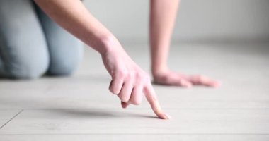 Parmak, ahşap zeminin yüzeyindeki toza dokunuyor. Temizlik servisi