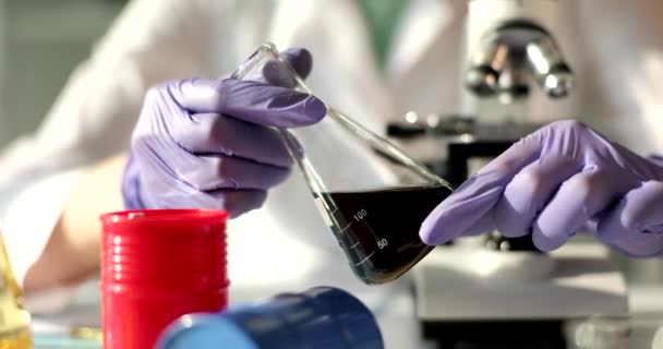 専門家の化学者は研究室で油でフラスコを保持しています 石油の性質と品質の科学者テストの概念 — ストック動画