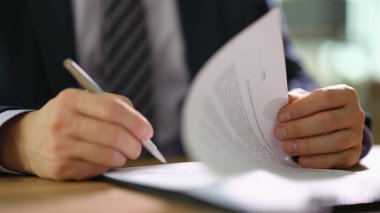 İş yerindeki takım elbiseli bir işadamı, iş yerindeki yakın çekimde belge imzalıyor. Ticari finans anlaşmaları kavramında strateji kazanmak