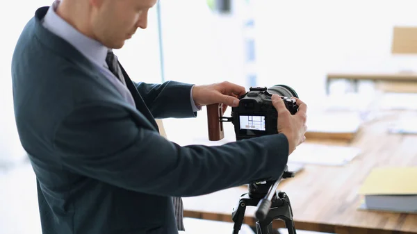 Businessman blogger adjusting camera to audience to shoot presentation. Freelance and business webinars concept