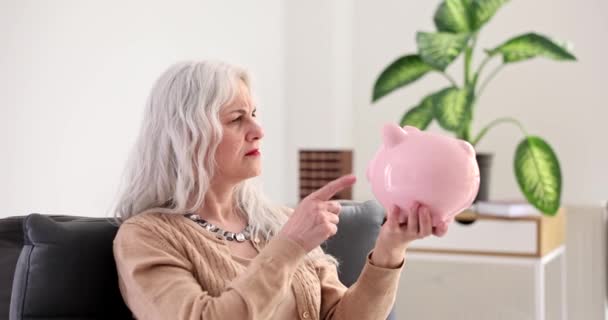 Inga Pensionssparande Och Frustrerad Äldre Kvinna Som Håller Tom Spargris — Stockvideo